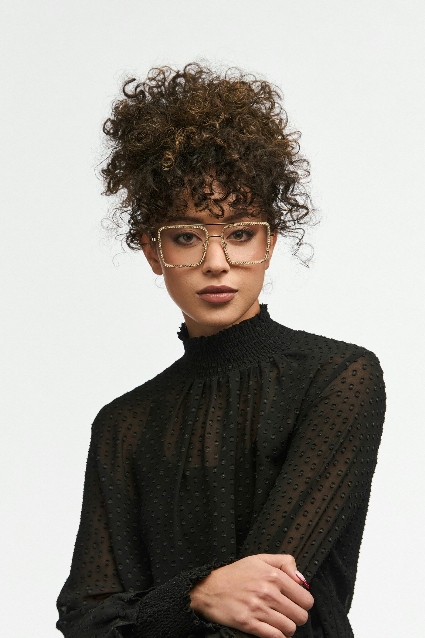 Woman wearing bold gold rhinestone square glasses